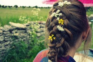 編んだ髪に花を飾りにしている女性の後ろ姿